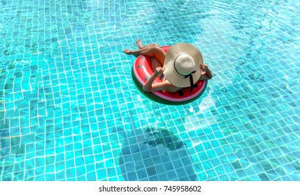 Woman bikini swimming pool on watermelon rubber ring relaxing vacation enjoying on summer season, Top view.
