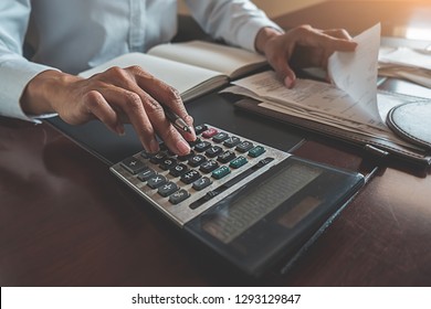 Woman with bills and calculator. Woman using calculator to calculate bills at the table in office. Calculation of costs.