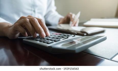 Frau mit Rechnungen und Taschenrechner. Frauen, die Rechner verwenden, um Rechnungen am Tisch im Büro zu berechnen. Berechnung der Kosten.
