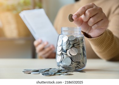 Woman With Bills And Savings Coin Jar To Pay Monthly. Bill Payment Or Inflation Concept With Saving Plan.