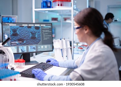 Woman Biotechnology Scientist Working At Computer Researching In Development Laboratory. Chemistry Research Technology In Science Medicine Lab Developing And Stying New Type Of Vaccine