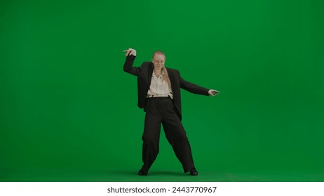 Woman in black business suit dancing cheerfully on green screen with chromakey. - Powered by Shutterstock