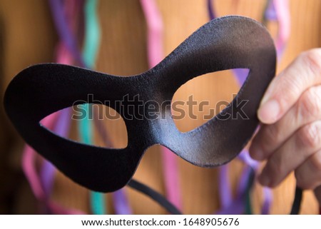 woman with black carnival mask and streamers, carnival party concept