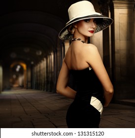 Woman In Black Dress And Big White Hat Alone Outdoors At Night