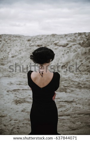 Similar – beautiful brunette short hair girl leaning against  gray rock wall outdoors, wearing black clothes