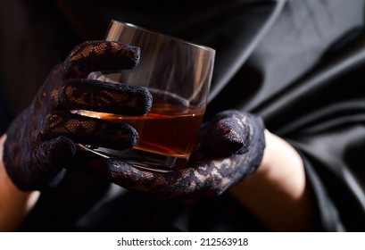 Woman In Black Gloves With Glass Of Whiskey