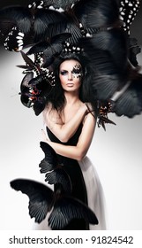 Woman with black hair and art make up and black butterflies