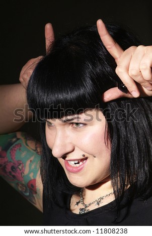 a woman with black hair and piercing shows horns