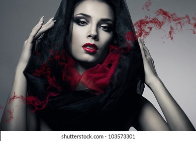 woman in black hood with smoke