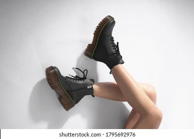  женщина в черных кожаных туфлях из новой коллекции на белом фоне женские ножки в модных туфлях из эко-кожи осень-зима 2022. Макет крупным планом                           