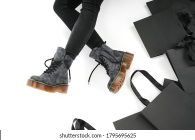  woman in black leather shoes from the new collection on a white background girl's legs in fashionable shoes made of eco-leather autumn-winter 2022. shoe box and bag on a white background             