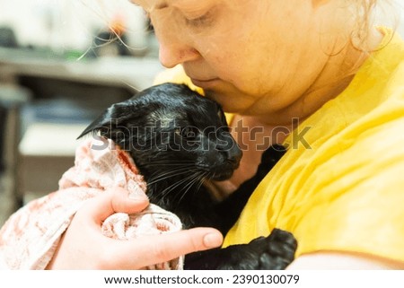 Woman with black oriental cat after bath