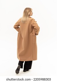 Woman In Black Pants And Brown Coat On White Background. Warm Coat For Autumn Or Winter. Rear View