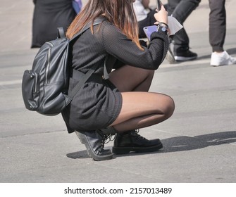 Woman In Black Pantyhose And Miniskirt Takes The Photos In The Square

