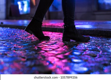 Woman In Black Shoes Walking Through The City Street In The Night