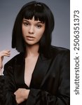 Woman, black suit, short bob hairstyle a woman in a sleek black suit stands confidently with her hands on her hips, gazing off to the side, her hair styled in an elegant short bob