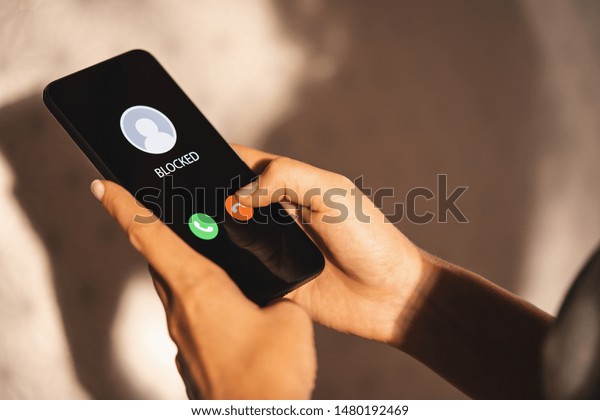 Woman Block a Phone Number or incoming Call from a\
anonymous stalker or Ex boyfriend. Stalking or bullying with phone\
concept. Stalker caller, scammer or stranger. Woman blocking\
incoming call.