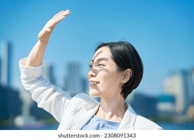 A woman blocking the strong sunlight with her hand