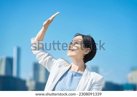 A woman blocking the strong sunlight with her hand [[stock_photo]] © 