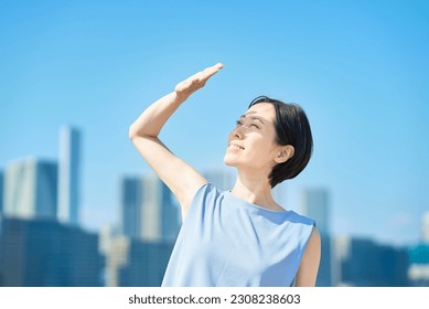 A woman blocking the strong sunlight under the blue sky