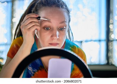 Woman Blogger Using Ring Light While Online Streaming About Applying Eyebrow Lacquer.