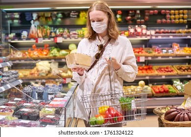 Woman With Blond Hair Wearing Medical Protection Mask Shopping For Groceries At The Supermarket. Buying Fresh Produce During Quarantine.