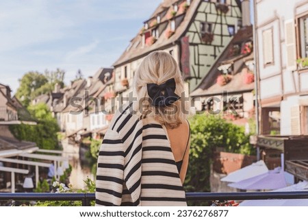 Woman with blonde hair wearing black bow on a hair. Fashionable details, French style