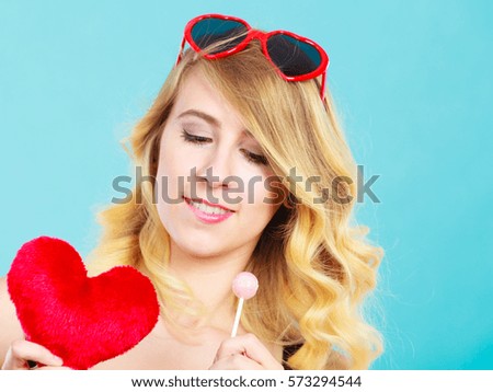Woman blonde lovely girl wearing dotted dress holding red heart love symbol and lollipop candy. Valentines day, happiness, sweet food concept