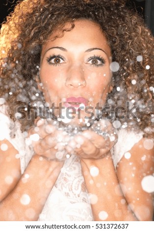 Woman blowing confetti from hands