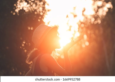 Woman Blowing Kiss And Holding Sun In Forced Perspective.