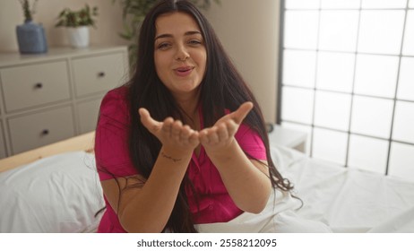 Woman blowing, kiss, while sitting in, bedroom, with long, black, hair wearing, pink, shirt - Powered by Shutterstock