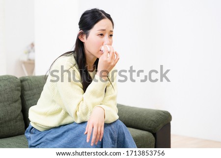 Woman blowing nose shot in studio