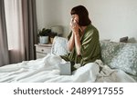 Woman, blowing nose and sick in home, allergies and tissue for illness or cold influenza in bedroom. Female person, sinusitis and recovery from virus or hayfever, bed and infection of flu or covid