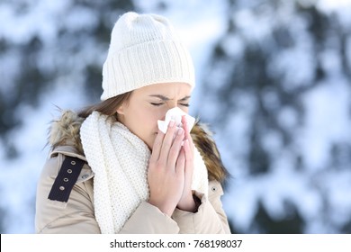 Woman Blowing In A Tissue In A Cold Winter With A Snowy Mountain In The Background