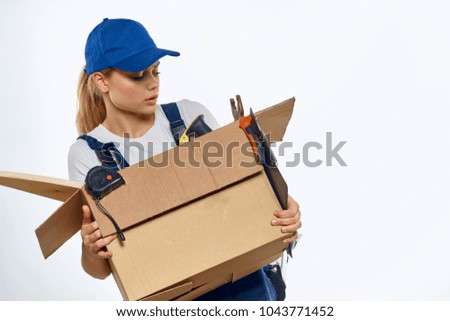 woman in blue cap, worker, courier, cardboard box                               