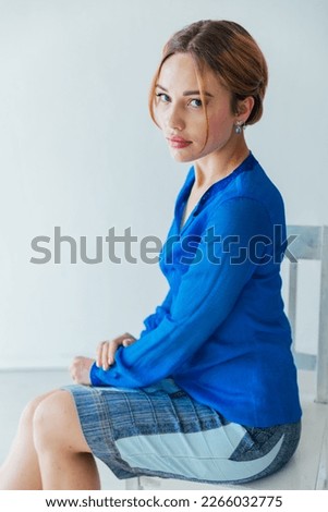 Young female sitting by table and making clay or ceramic mug in her working studio