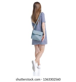 Woman in blue dress with bag looking walking goes on white background isolation, back view