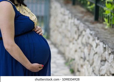 Woman In Blue Holding Baby Belly