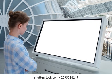 Woman In Blue Plaid Shirt Looking At Blank Interactive Touchscreen White Display Of Electronic Kiosk At Futuristic Exhibition Or Museum. White Screen, Mock Up, Copyspace, Template, Technology Concept.