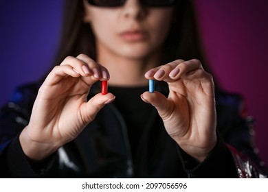 Woman with blue and red pills on dark background. Concept of choice