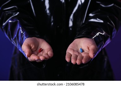 Woman with blue and red pills on dark background, closeup. Concept of choice