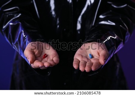 Woman with blue and red pills on dark background, closeup. Concept of choice