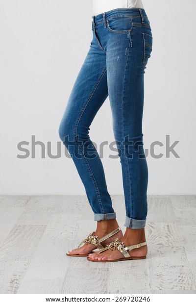 Woman in\
blue skinny jeans on the white\
background