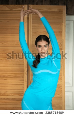 Woman in blue sport clothes at home