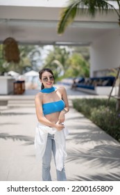 Woman In Blue Top And Jeans Walking In Tropical Resort Hotel.