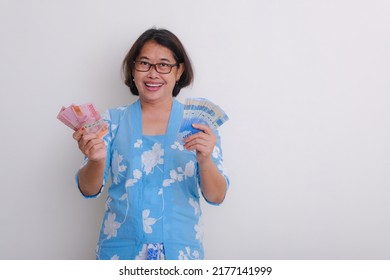 A Woman In Blue With White Floral Print Dress Holding Some Money; Happy Smiling.