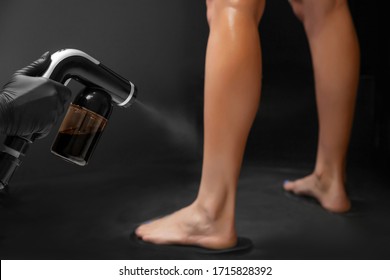 Woman Body Paint With Airbrush Spray Tan In Professional Beauty Salon On Black Background.