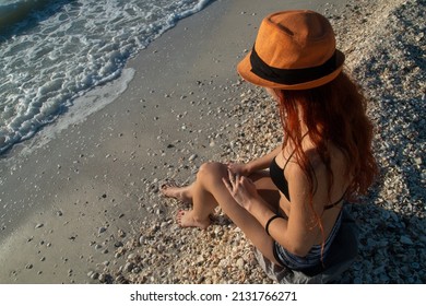 Woman Body With Sun Hat On Beach With A Lot Of Shells, Shelling Beaches Of Sanibel Island And Captiva, Florida