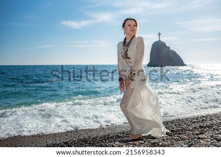 Woman in bohemian clothing on beach at sunset. Boho style for fashionable look on resort. Middle aged well looking woman in white dress and boho style braclets. Summer fashion