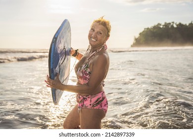 A woman with Boogie board on the beach at the sunset - Powered by Shutterstock